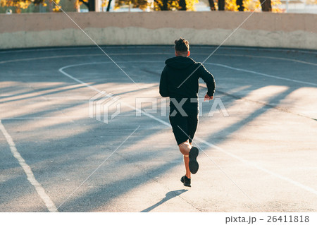Runner on track at sport stadium, free space 26411818