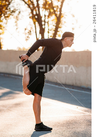 Sprinter warming-up his legs before training 26411819