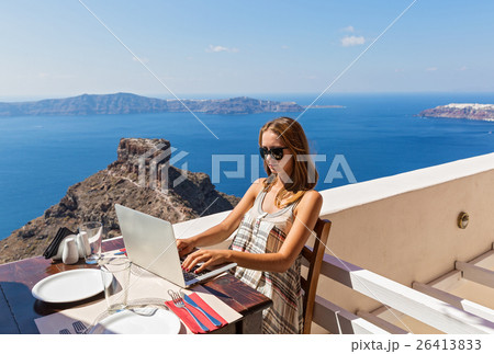 Woman working at a computer on the seafront. 26413833