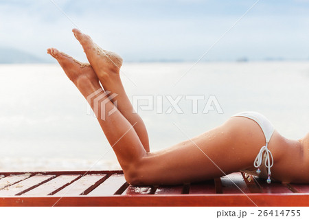 beautiful young slim woman legs sunbathe on beach beautiful young slim woman legs sunbathe on beach 26414755