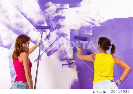 women paints white wall with purple paint roller women paints white wall with purple paint roller 26414986