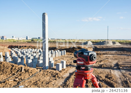 Theodolite in front of piles field 26425136