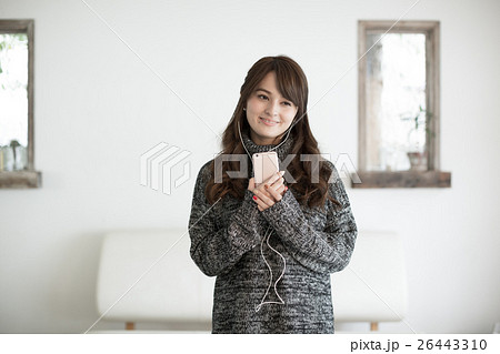 スマホで音楽を楽しむ若い女性 26443310