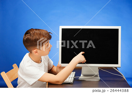 School-age boy sitting with the monitor laptop at School-age boy sitting with the monitor laptop at 26444388