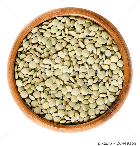 Green lentils in wooden bowl over white 26449368