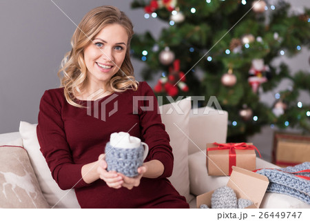 Cheerful pretty woman offering you a cup of cocoa Cheerful pretty woman offering you a cup of cocoa 26449747