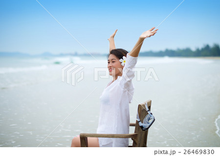 Girl with arms wide open on chair at beach 26469830