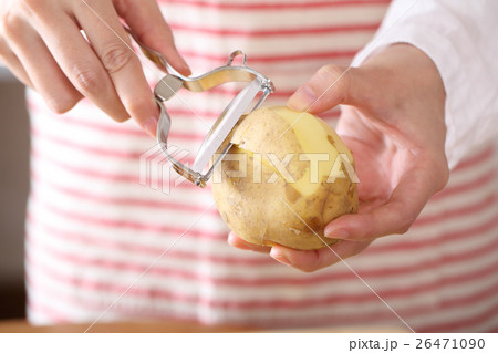 ピーラーでジャガイモの皮をむく女性 26471090
