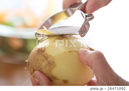 ピーラーでジャガイモの皮をむく女性 26471092
