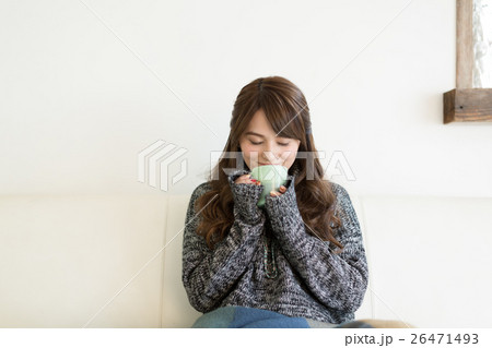 リビングのソファーでホットコーヒーを飲む若い女性 リビングのソファーでホットコーヒーを飲む若い女性 26471493