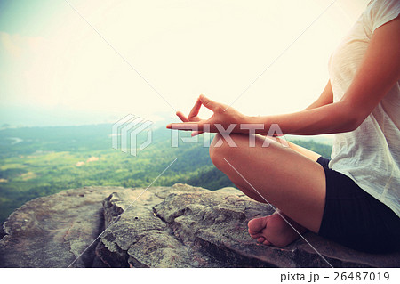 woman practice yoga at mountain peak cliff 26487019