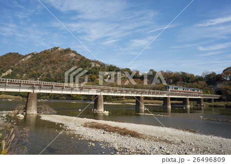 紅葉する山々の間の鉄橋を渡るローカル電車（ＪＲ姫新線と揖保川） 26496809