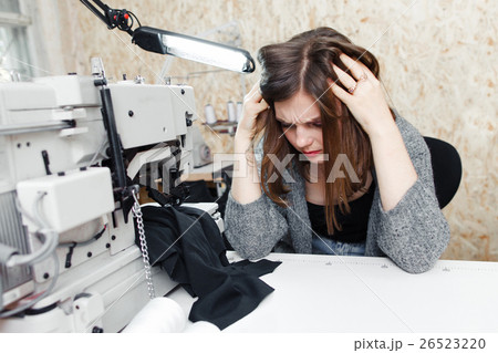 Tailor with strong headache at sewing machine 26523220