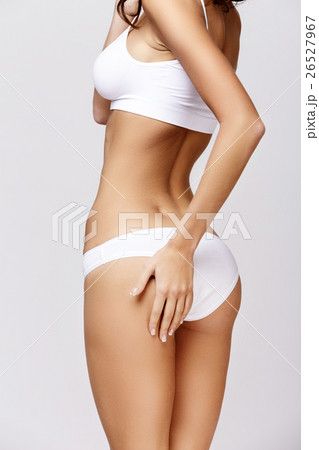 Slim tanned woman's body over gray background Slim tanned woman's body over gray background 26527967