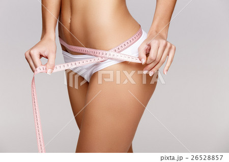 Slim tanned woman's body over gray background 26528857
