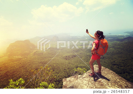 young woman hiker taking photo with smartphone   26548357
