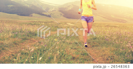 young fitness woman runner running on grassland young fitness woman runner running on grassland 26548363