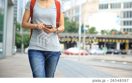 young woman walking with smart phone young woman walking with smart phone 26548397