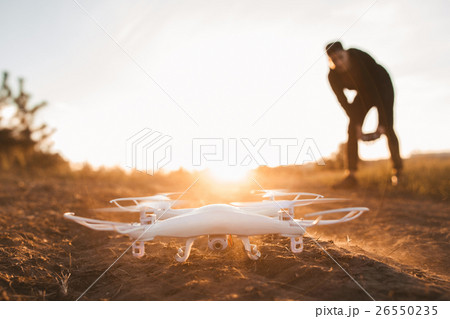 Pilot landing drone outdoor, sunset, free space Pilot landing drone outdoor, sunset, free space 26550235