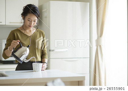 カップにお湯を注ぐ若い女性 26555901