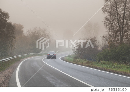 Foggy road, car goes on empty highway 26556199
