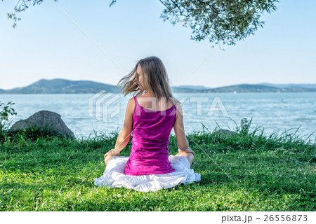 Woman meditating at the lake Woman meditating at the lake 26556873
