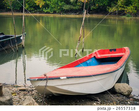 An old fishing boat fastened to a wooden sticks on 26557318