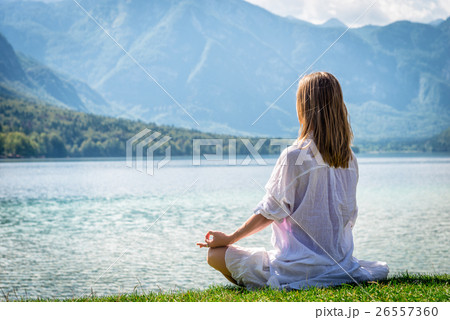 Woman meditating at the lake Woman meditating at the lake 26557360