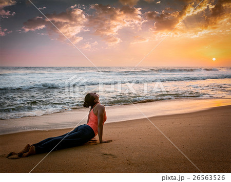 Woman practices yoga asana Urdhva Mukha Svanasana Woman practices yoga asana Urdhva Mukha Svanasana 26563526