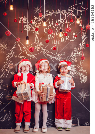 Children dressed as Santa Claus standing and 26564162