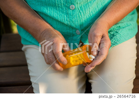 Hand of woman holding pills. 26564716