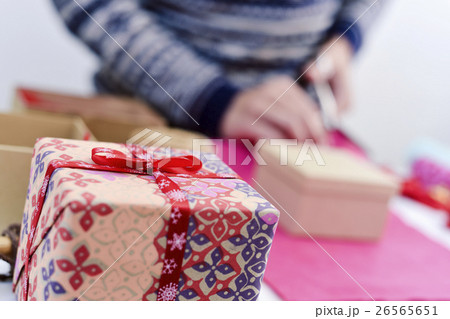 young man wrapping a gift young man wrapping a gift 26565651