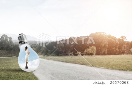 Businesswoman inside light bulb Businesswoman inside light bulb 26570068