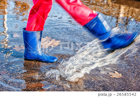 girl standing in a puddle of water splashes girl standing in a puddle of water splashes 26585542