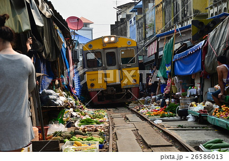 タイ バンコクのメークロン市場 線路上の屋台をたたんで電車が通過する光景の写真素材