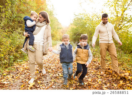 Beautiful young family on a walk in autumn forest. 26588851