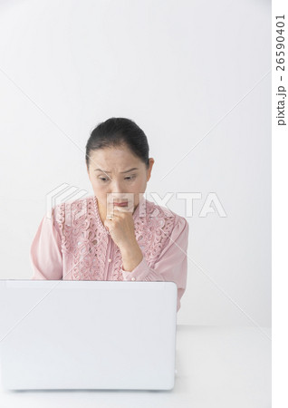 パソコンの前で考え込むシニア(ミドル)女性 パソコンの前で考え込むシニア(ミドル)女性 26590401