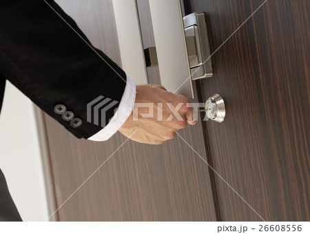 鍵を閉める男性の手元 26608556