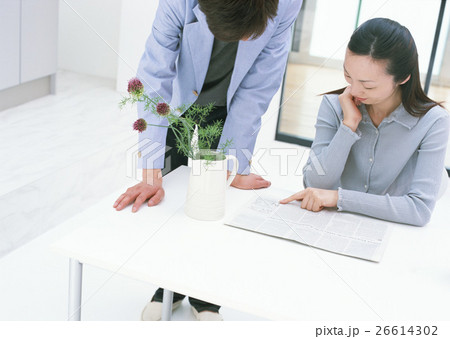 新聞を読む男女 26614302