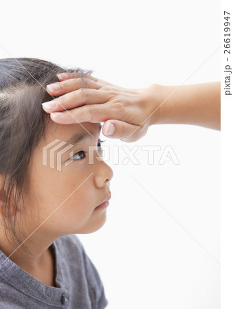 娘の額に手をあてる母親の手 26619947