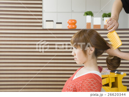 髪をとかしてもらう若い女性 26620344