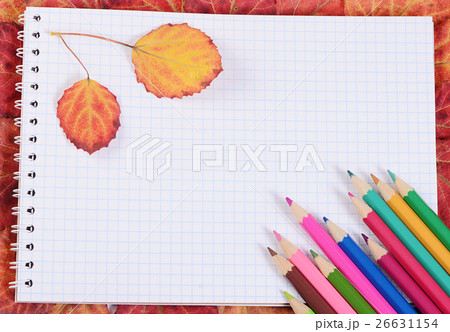 Colored pencils with a notebook and autumn leaves 26631154