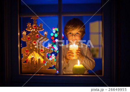 Little kid boy standing by window at Christmas 26649955