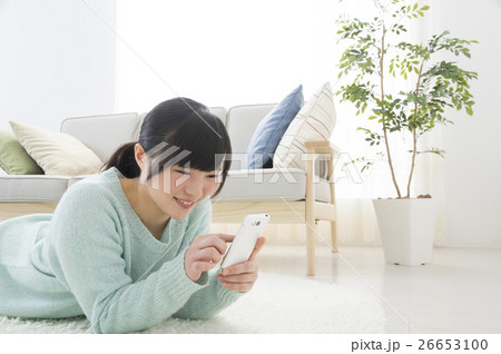 リビングでスマホを見る女性 26653100