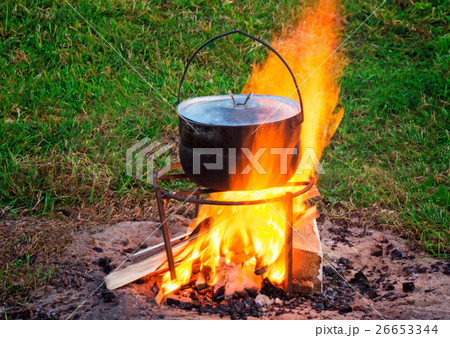 On a fire there is a pan in  the food is cooked. 26653344