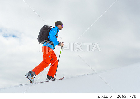Man with ski mountaineering climb towards the summit 26654779