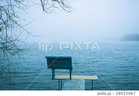Lonely bench overlooking a winter lake or sea 26655067