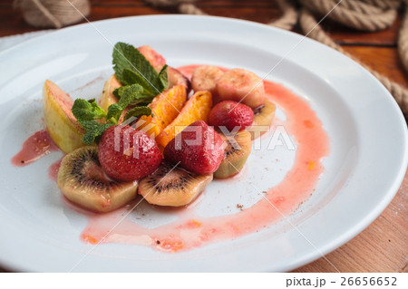 Fruit flambe on white plate. 26656652