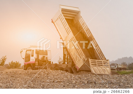 Dump truck is dumping gravel on an excavation site 26662266