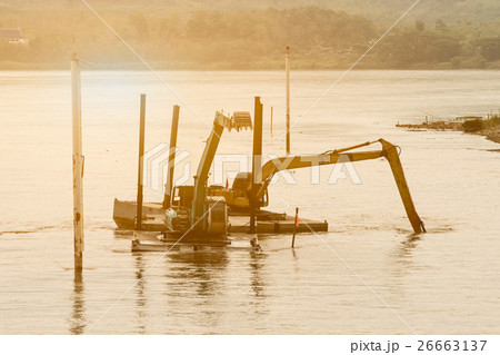 Two shovel buckets on pontoon are dig mud. 26663137
